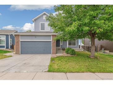 Charming two-story home features blue siding, brick accents, and an attached two-car garage at 15762 Olmsted Pl, Denver, CO 80239