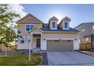 Charming two-story home with a two-car garage and well-maintained front yard with grass and rock at 9099 Sedalia St, Commerce City, CO 80022