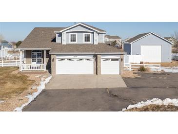 Two-story house with attached two-car garage and a detached garage at 16530 Timber Cove St, Hudson, CO 80642