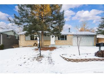 Ranch-style home with gray siding, attached garage, and snow-covered lawn at 670 S Oswego St, Aurora, CO 80012