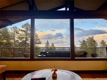 Inviting living room featuring large windows with scenic views and comfortable seating at 21437 Alta Dr, Morrison, CO 80465