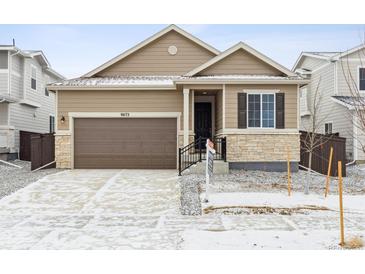 Charming single-Gathering home featuring a stone-accented facade and attached two-car garage at 9673 Ceylon St, Commerce City, CO 80022