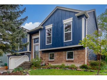 Two-story home with blue siding, brick accents, well-manicured lawn, and a welcoming front entrance at 10370 Routt St, Westminster, CO 80021