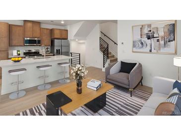 Cozy living room featuring modern furnishings, an open staircase and neutral tones, creating an inviting atmosphere at 2042 S Holly St # 3, Denver, CO 80222