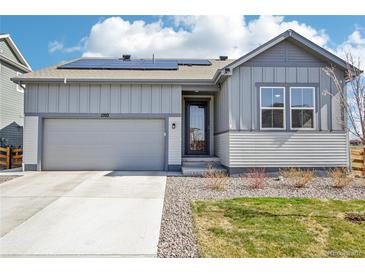 Charming single-Gathering home featuring solar panels, a gray facade, a well-kept lawn, and an attached garage at 1702 Metcalf Dr, Erie, CO 80516