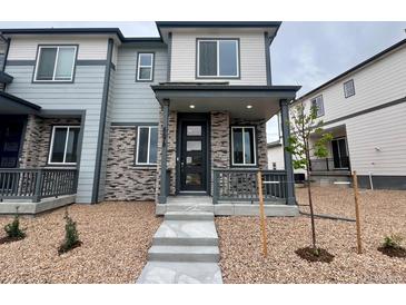 Inviting two-story home with stone accents, covered porch, and well-maintained landscaping at 6678 N Nepal Ct, Aurora, CO 80019