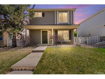 Charming two-story home with front porch, landscaped yard and a well-maintained lawn at 21562 E 47Th Ave, Denver, CO 80249