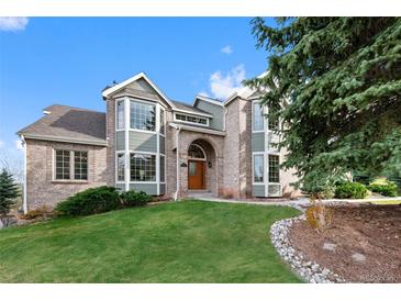 Beautiful two-story brick home with arched entryway and well-maintained landscaping at 87 Deerwood Dr, Littleton, CO 80127