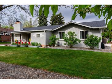 Charming single-story home featuring a well-manicured lawn, brick facade, and lovely flowerbeds at 1601 S Glencoe St, Denver, CO 80222