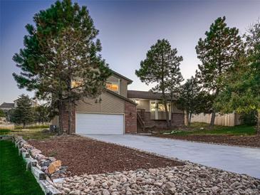 Charming two-story home featuring a brick and siding exterior with a two-car garage and a well-manicured front yard at 8916 Sunridge Hollow Rd, Parker, CO 80134