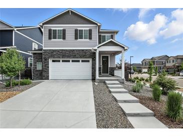 Charming two-story home with gray siding, stone accents, a two-car garage, and well-manicured landscaping at 27504 E 1St Pl, Aurora, CO 80018