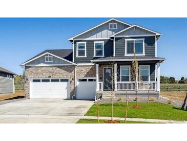 Charming two-story home with a stone facade and a well-manicured front yard at 1102 Ridgefield Dr, Berthoud, CO 80513
