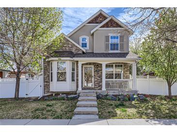 Charming two-story home boasts a welcoming front porch and beautifully maintained landscaping at 736 Trenton St, Denver, CO 80230
