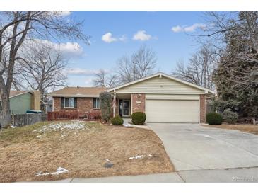 Charming single-story home featuring a brick facade, two-car garage, and well-maintained front yard at 8205 Dudley Way, Arvada, CO 80005