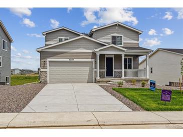 Charming two-story home featuring a covered porch, well-kept lawn, and an attached two-car garage at 42754 Calusa Pines Rd, Elizabeth, CO 80107