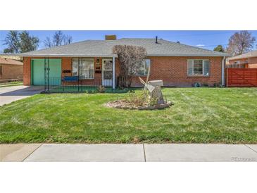 Charming home with a lush green lawn and decorative windmill at 891 Ursula St, Aurora, CO 80011