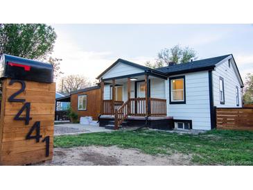 Charming home featuring fresh white siding, black trim, front porch, and easy-to-read address numbers on the mailbox at 2441 W 55Th Ave, Denver, CO 80221
