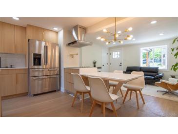 Modern kitchen with stainless steel appliances, a sleek island, and an open dining area perfect for gatherings at 2441 W 55Th Ave, Denver, CO 80221