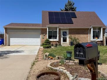 Charming brick home featuring solar panels, a well-manicured lawn, and a mailbox with the house number at 4383 S Eagle Cir, Aurora, CO 80015