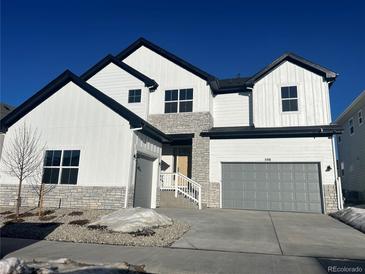 Two-story farmhouse style home with gray garage and stone accents at 598 Coal Bank Trl, Castle Rock, CO 80104