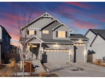 Beautiful two-story home with stone accents, three car garage, gray siding and a landscaped front yard at 21901 E 42Nd Pl, Aurora, CO 80019