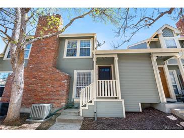 Charming home with red brick chimney, grey siding, and inviting front entry at 1981 S Hannibal Ct # B, Aurora, CO 80013