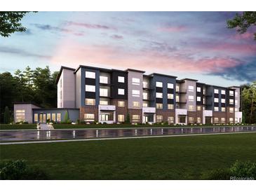Modern apartment building featuring a combination of gray and dark blue exterior and well-maintained green lawn at 485 Interlocken Blvd # 106, Broomfield, CO 80021