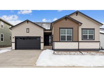 Two-toned house with dark brown garage door and snowy front yard at 16850 Mckay Dr, Mead, CO 80542