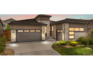 Inviting two-story home with a two-car garage, stone accents, and manicured landscaping at 11193 Mission Walk St, Parker, CO 80134