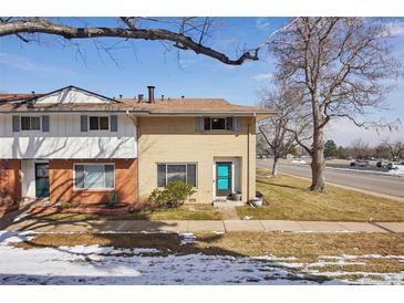 Charming townhouse featuring a striking turquoise door and a well-maintained lawn at 12531 W Alameda Dr, Lakewood, CO 80228