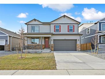 Two-story house with gray siding, red accents, and a two-car garage at 9902 Cathay St, Commerce City, CO 80022