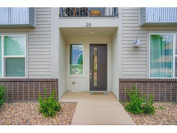 Inviting home entrance with a modern door, brick accents, and well-maintained landscaping at 8711 E Hampden Ave # 26, Denver, CO 80231