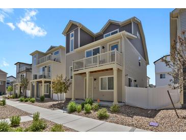 Charming multi-level townhome with balconies, neutral siding, and landscaped front yard at 18233 E 51St Ave, Denver, CO 80249