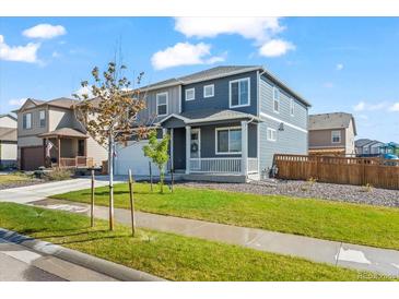 Charming two-story home with a well-maintained lawn and inviting front porch at 902 William Way, Brighton, CO 80603