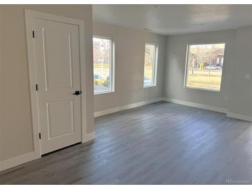 Bright living room featuring large windows, modern floors, and neutral paint tones at 1652 N Lafayette St # 6, Denver, CO 80218