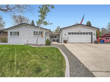 Charming home featuring a brick facade, well-manicured lawn, and an attached two-car garage at 1025 Zang St, Golden, CO 80401