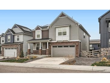 Two-story home boasting gray siding, brick accents, and a two-car garage at 9771 Rosalee Peak St, Littleton, CO 80125