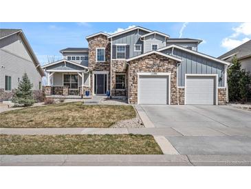 Beautiful two-story home with stone accents, a three-car garage, and a well-manicured lawn at 11584 Pine Canyon Ln, Parker, CO 80138