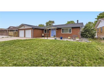Charming red brick home with a well-maintained front yard and blue door at 865 S 8Th Ave, Brighton, CO 80601