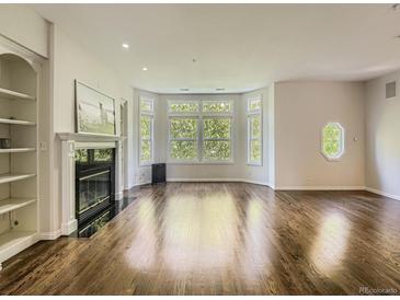 Spacious living room features hardwood floors, a fireplace, and large windows letting in ample natural light at 30 Garfield St # B, Denver, CO 80206