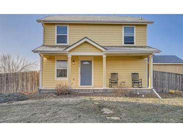 Charming two-story home with a welcoming front porch and well-maintained yard at 55410 E 27Th Pl, Strasburg, CO 80136