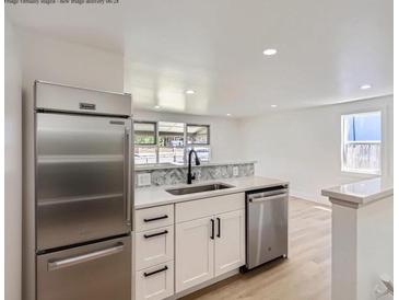 Bright kitchen features stainless steel appliances, white cabinets, and sleek countertops at 235 S Stuart St, Denver, CO 80219