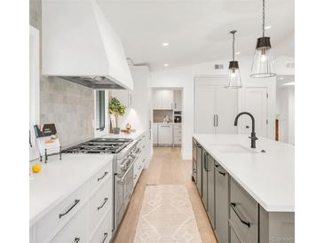 Bright kitchen featuring stainless steel appliances, large island, and custom hood range at 4930 E Ellsworth Ave, Denver, CO 80246