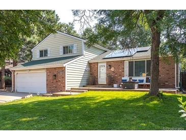 Charming two-story home with a brick facade, solar panels, and a well-maintained lawn at 2254 S Eagle St, Aurora, CO 80014