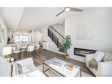 Bright living room featuring modern fireplace, open floor plan, and stylish decor at 3481 W 63Rd Ave, Denver, CO 80221