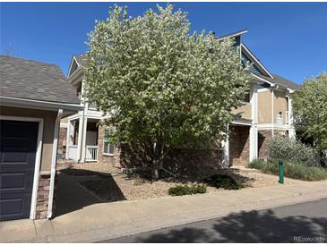 Charming townhome exterior featuring stone accents and a beautiful, mature flowering tree in the front yard at 8200 E 8Th Ave # 5-204, Denver, CO 80230