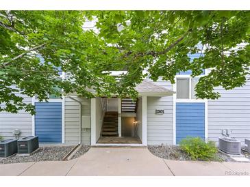 Inviting entrance with stairs and blue-grey walls and a small garden at 1301 S Cathay Ct # 104, Aurora, CO 80017