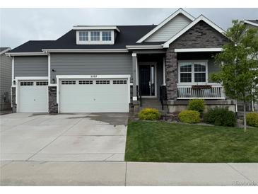 Charming two-story home featuring a three-car garage, stone accents, and well-manicured landscaping at 5597 Pinto Valley St, Parker, CO 80134
