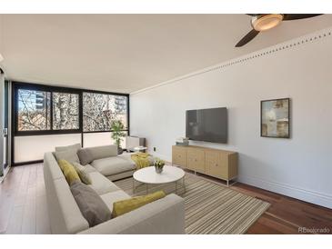 Bright living room featuring hardwood floors, large windows, and modern decor, with a cozy sectional sofa at 1050 N Corona St # 308, Denver, CO 80218
