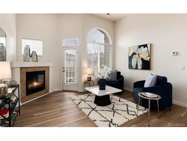Bright living room with a fireplace, large windows, and stylish decor at 341 Granby Way # A, Aurora, CO 80011